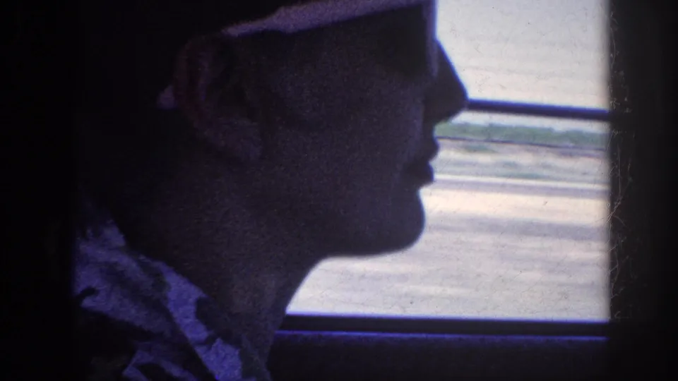 A 1963 Memphis-area car-interior shot shows the passenger in profile, wearing white sunglasses against the bright roadside blur.