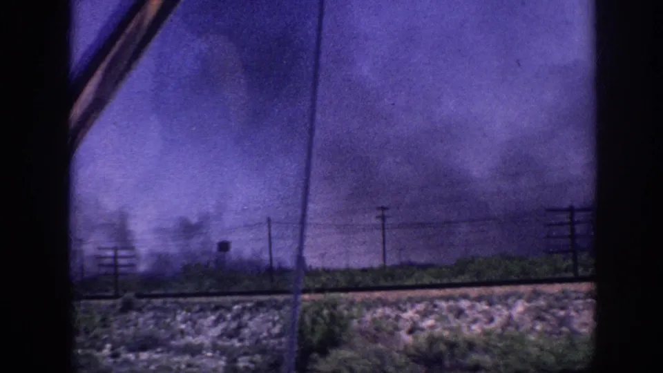 8mm home movie view through car window of advancing storm clouds over flat landscape with rows of utility poles, Memphis Tennessee area, circa 1963.