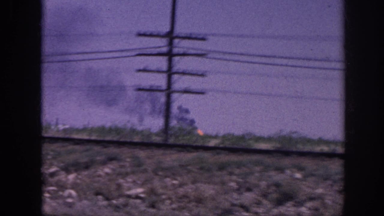 Wooden utility pole with multiple cross-arms and wires dominates the right; distant fire glows at the horizon under a purple sky.