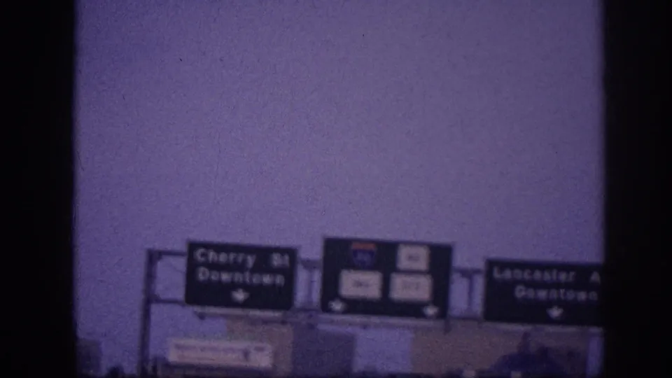 1963 Memphis 8mm frame with Cherry Street Downtown and Lancaster Avenue Downtown signs visible above a roadway approach.