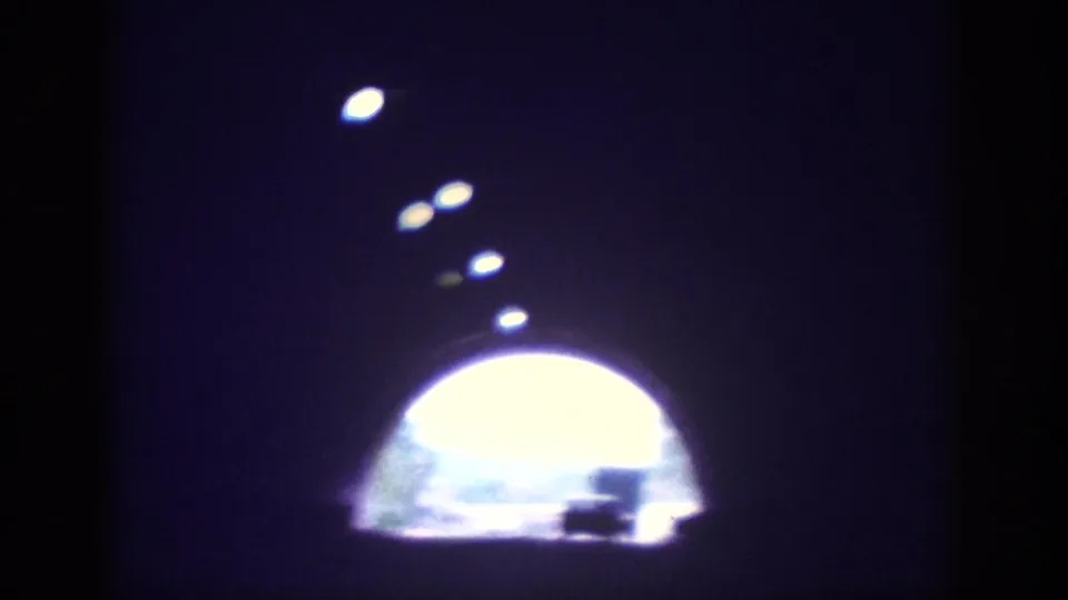 Interior-tunnel POV on 8mm circa 1963, looking toward the arched daylight exit with a vehicle silhouette visible through the opening.