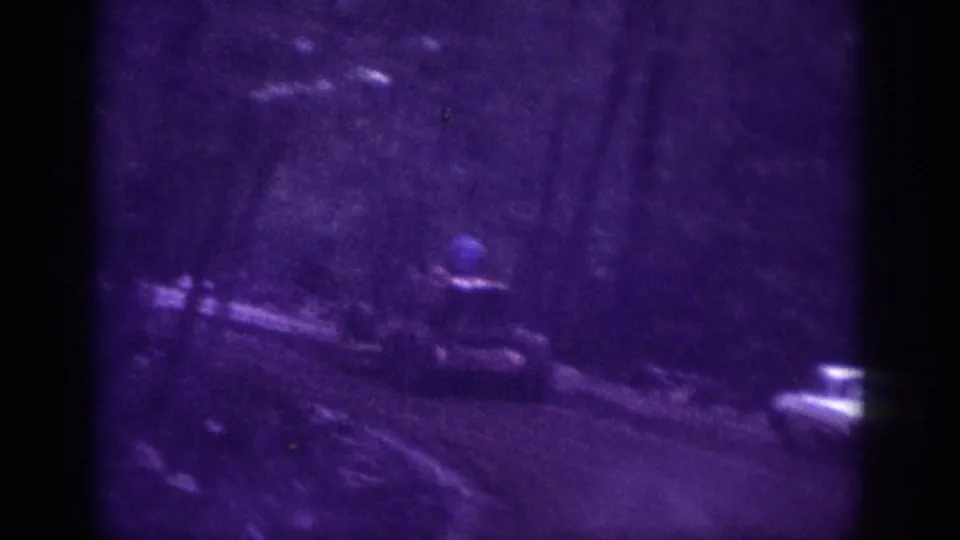 Dirt road through wooded area, possibly Memphis Tennessee circa 1963; an ambiguous blue object in the lower frame is unidentified and warrants human review.