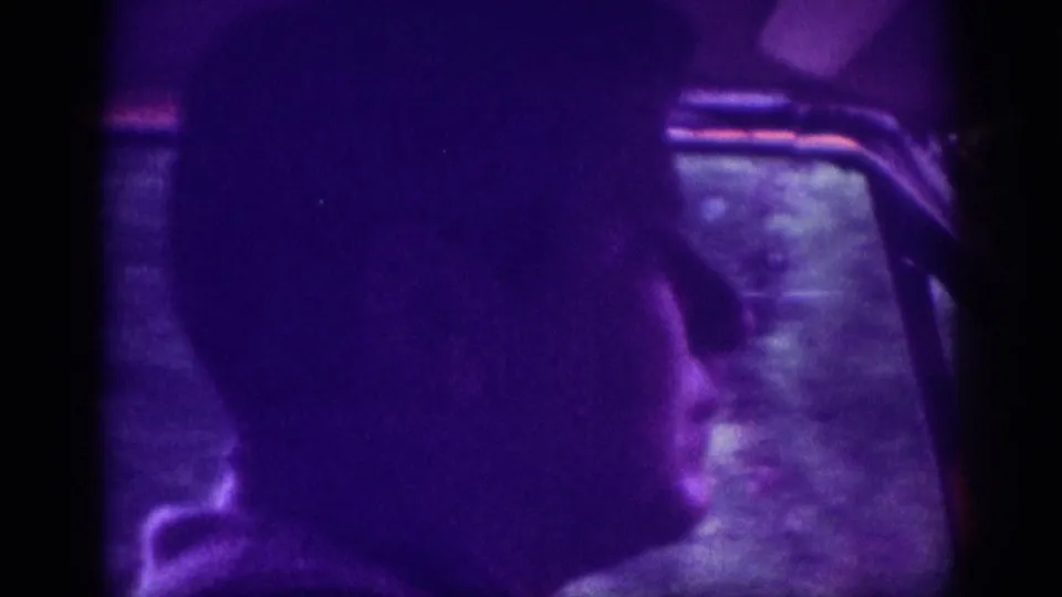 Interior 8mm shot capturing a driver's silhouette against a dark window, taken during a drive through Memphis in 1963.