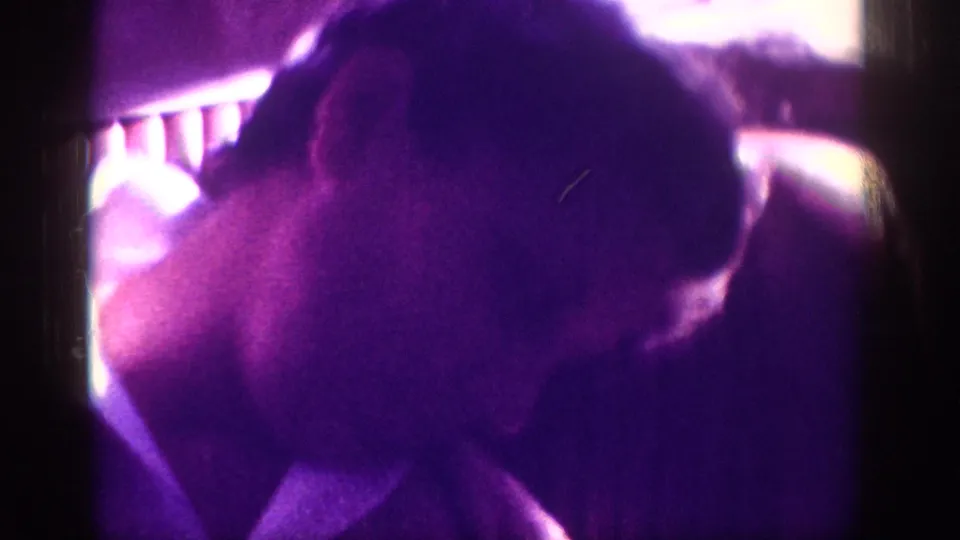 Close-up of sleeping child's head in car interior with window-light overexposure and purple dye-fade, 8mm family footage, circa 1963.