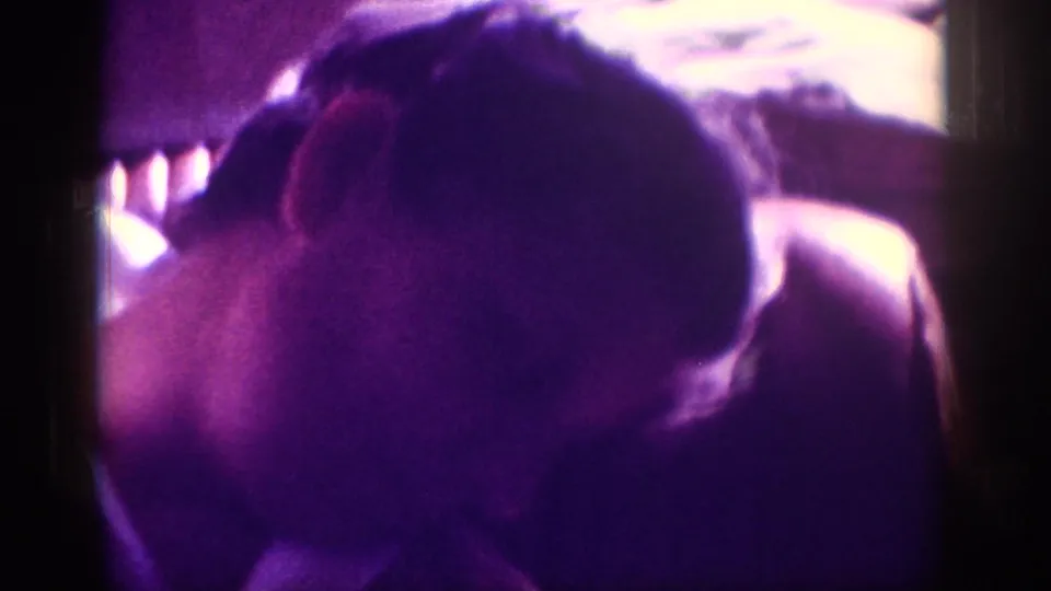 Sleeping child's head in car seat, window flare and heavy purple dye-fade, 8mm family travel footage, circa 1963.