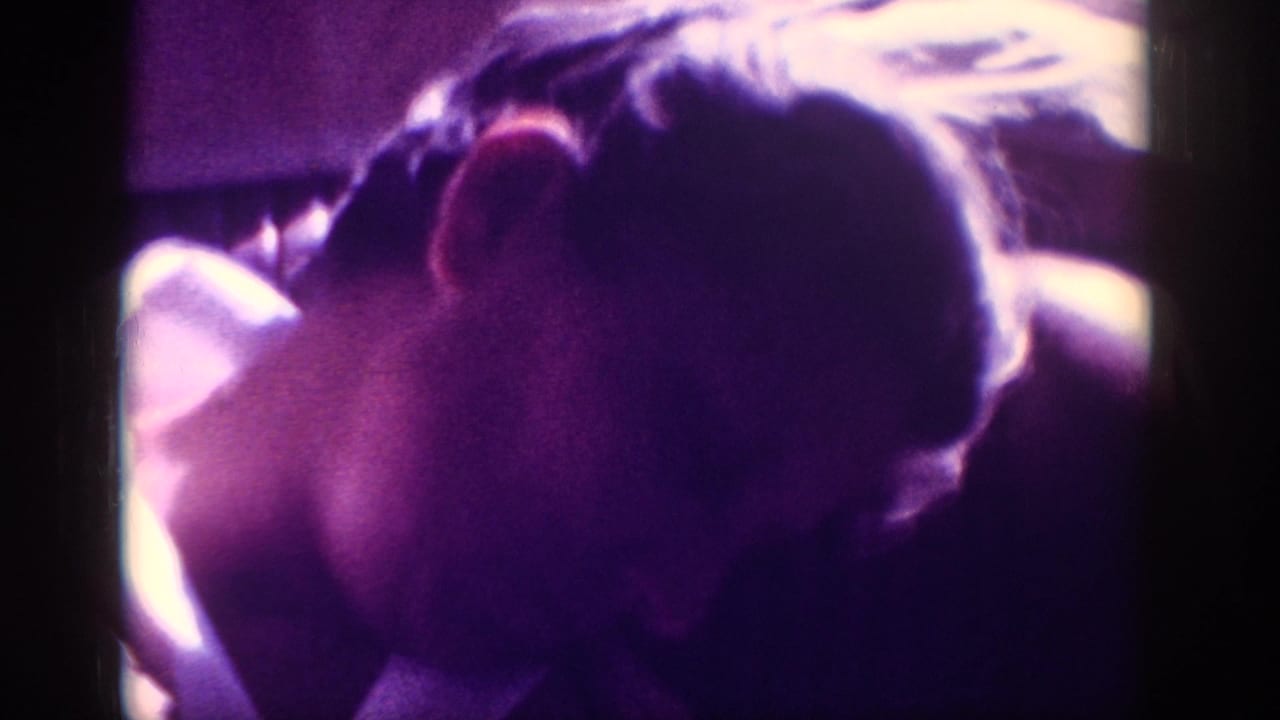 Rear-overhead view of a man's downward-tilted head on aged 8mm stock with strong magenta color shift, metadata-attributed to Memphis, Tennessee, circa 1963.