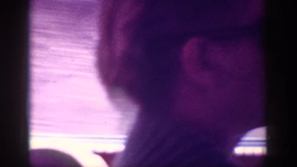 Very close, out-of-focus shot of the back of a man's head in a magenta-cast 8mm home movie frame, metadata-attributed to Memphis, Tennessee, circa 1963.