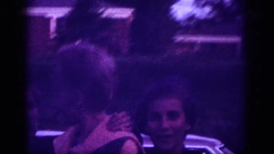 Motion-blurred handheld frame of two figures outdoors, likely Memphis, Tennessee, circa 1963; camera pan on aged 8mm stock.