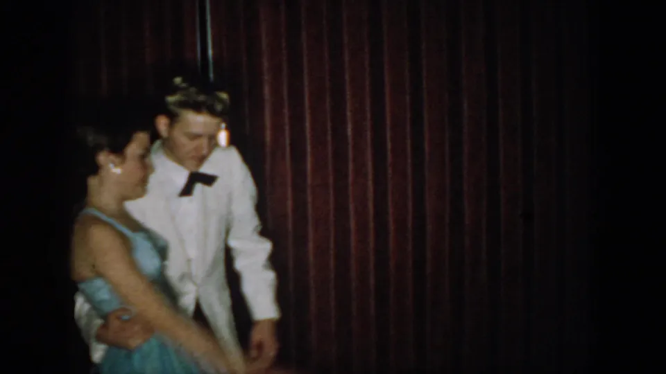 8mm home movie, circa 1965, Saint Louis, Missouri: young couple in formal dance hold facing camera; man's black bow tie and woman's blue strapless gown clearly visible.