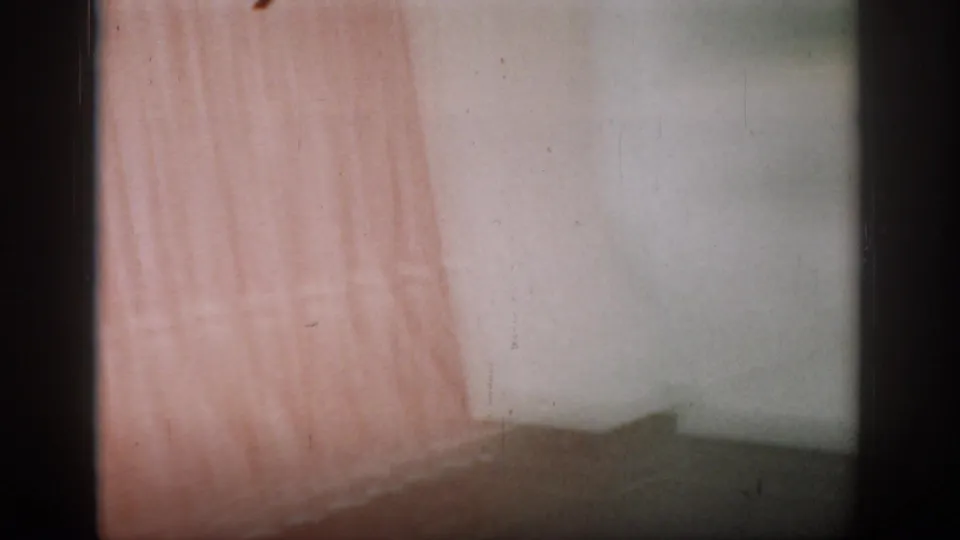 Final clip frames show only a lighter-toned curtain against a plain pale wall; subjects are out of frame, likely a camera pan at the clip's end.