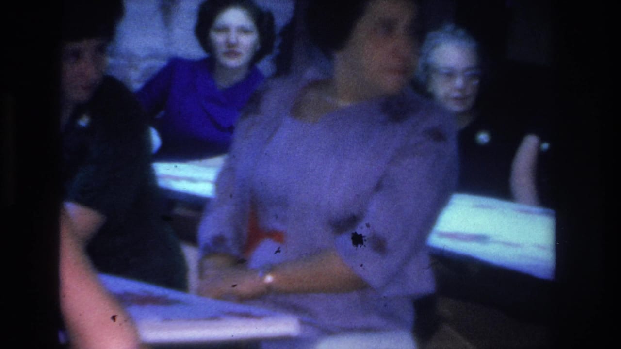 Women in period dress at an indoor gathering, Hoboken, New Jersey area, circa 1966; film dust and color shift are typical of 1960s 8mm stock.