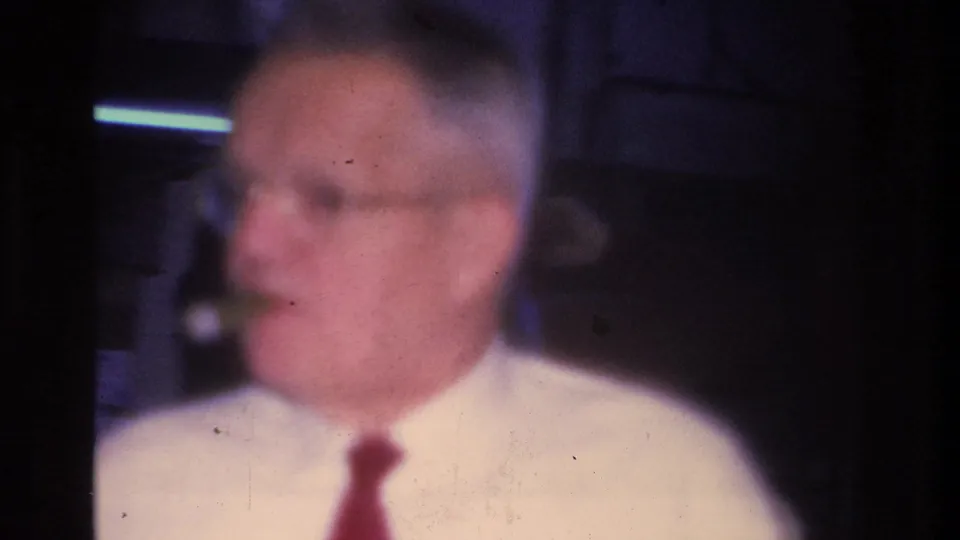 Close-up of a man in a white shirt and red tie addressing a gathering, Hoboken, New Jersey, 1966; image is soft due to handheld 8mm close-up in low light.