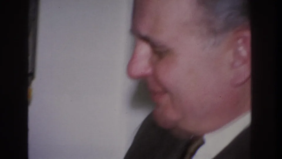 Soft-focus profile of middle-aged man in dark business suit with downward gaze; domestic interior, Hoboken, New Jersey, circa 1966 per metadata.