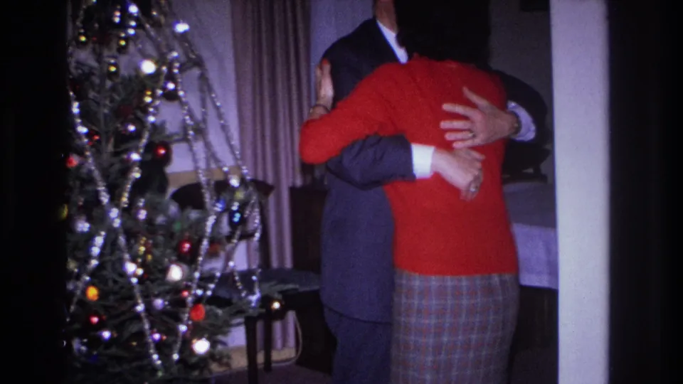A close holiday embrace continues in the 1966 Hoboken home movie, with tinsel and ornaments visible at left.