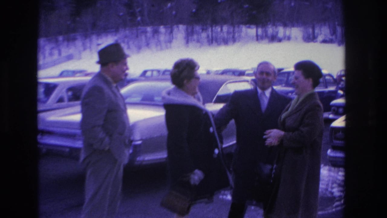 Four adults in mid-1960s winter attire, fedoras and fur-collar coats, greeting in a busy parking lot; dated circa 1966, Hoboken, New Jersey per metadata.