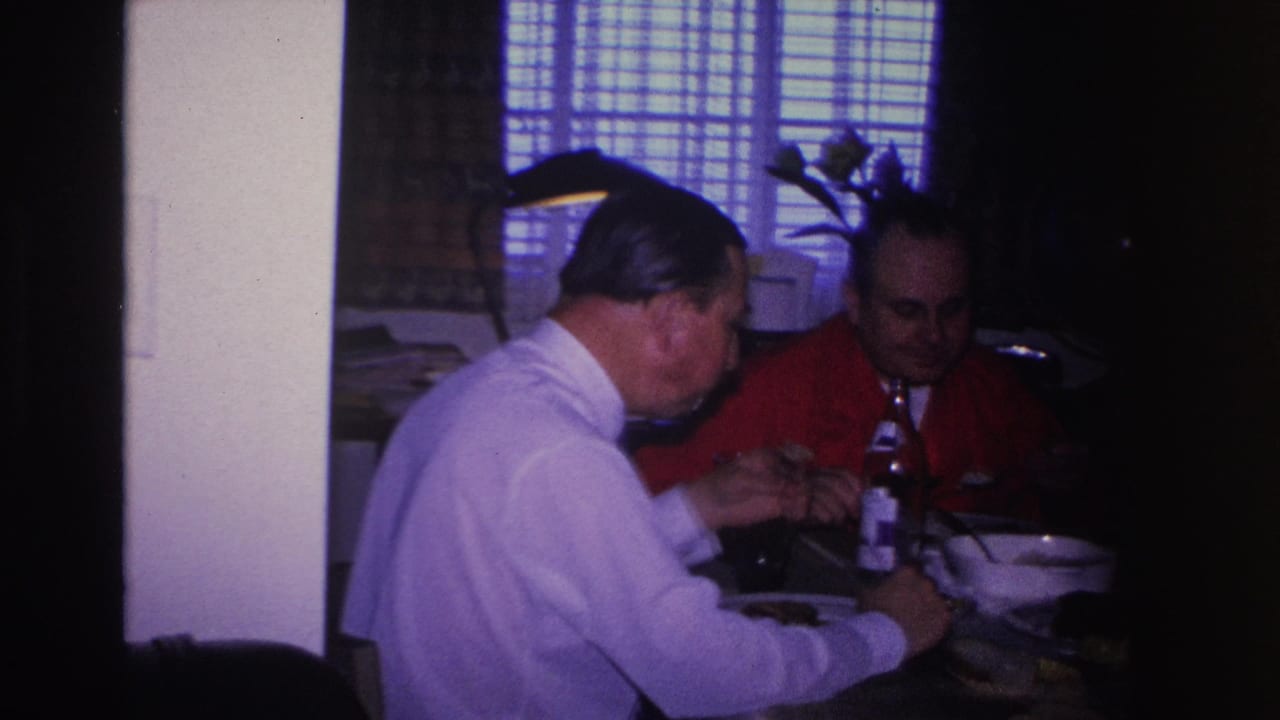 Two adult men eating from bowls at a private home dining table, Hoboken, New Jersey, circa 1966; 8mm footage with blue-shifted background light.