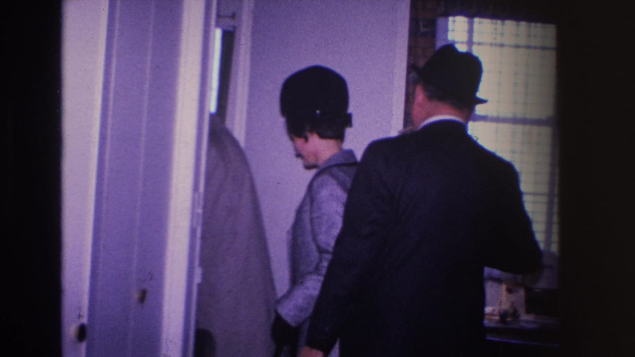 8mm home movie frame from approximately 1966 showing two formally dressed adults entering a room through an interior door, Hoboken, New Jersey.