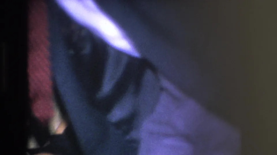 Opening frame of a 1966 8mm home movie showing a man in a dark suit and red tie stepping aside; image is motion-blurred with light halation.