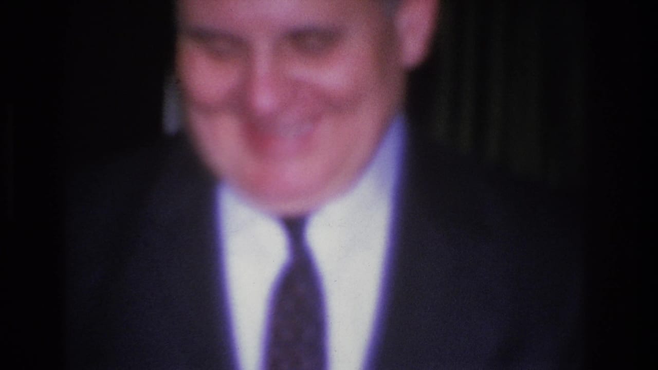 8mm close-up of a smiling man in a dark suit and narrow tie at a social event, Hoboken, New Jersey, 1966.