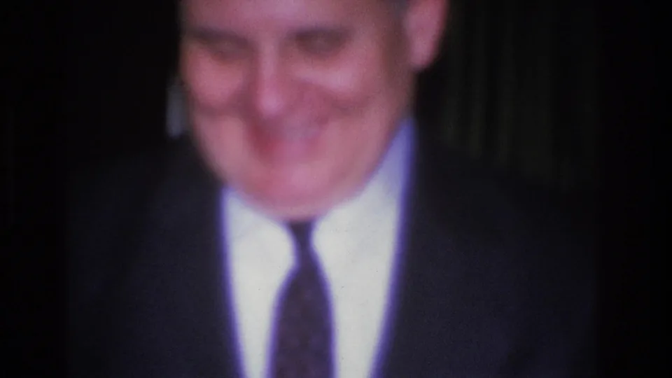 8mm close-up of a smiling man in a dark suit and narrow tie at a social event, Hoboken, New Jersey, 1966.