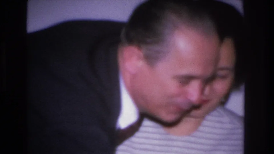 Closing frame of a 1966 8mm home movie: couple lean close together in a shared affectionate exchange, attributed to Hoboken, New Jersey.