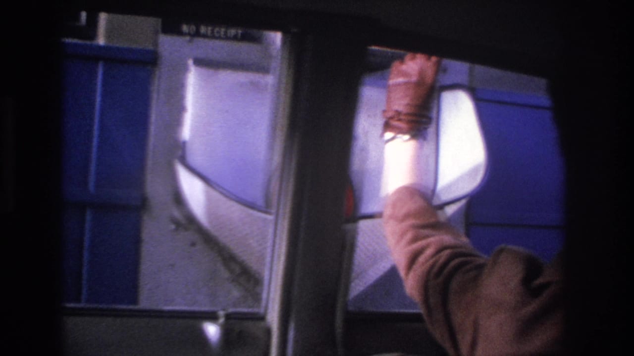 Close view of a woman's arm in a brown sleeve extended through a car window toward an illuminated toll coin basket; 'NO RECEIPT' text visible on booth.