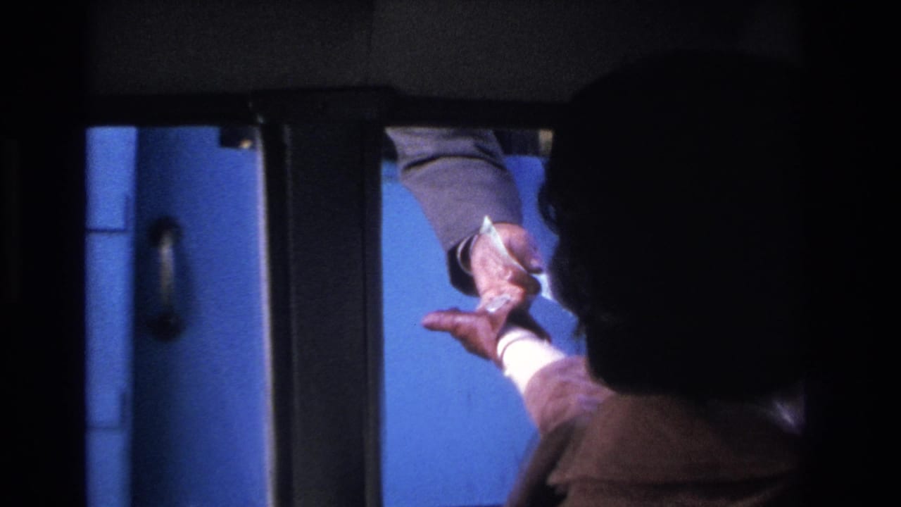 Two hands exchanging paper money through a car window opening; one gloved hand extending bills, another receiving them against a blue background.