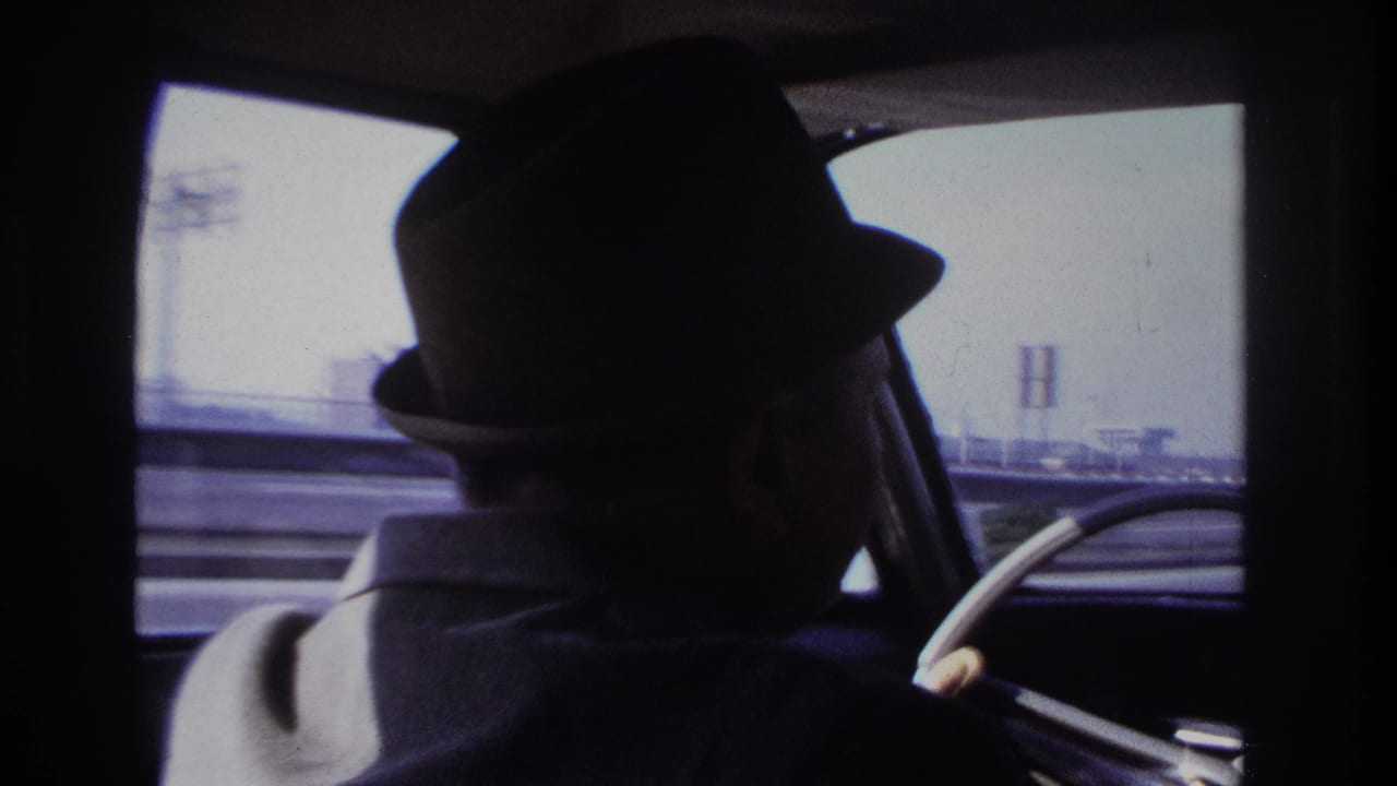 Final frame of the 1966 Hoboken driving clip, with the fedora-wearing driver silhouetted inside the moving car.