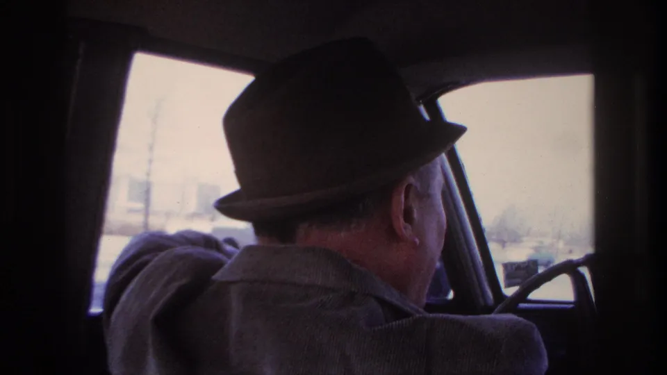 1966 Hoboken driving view from behind the driver, with the steering wheel and washed-out city scene ahead.