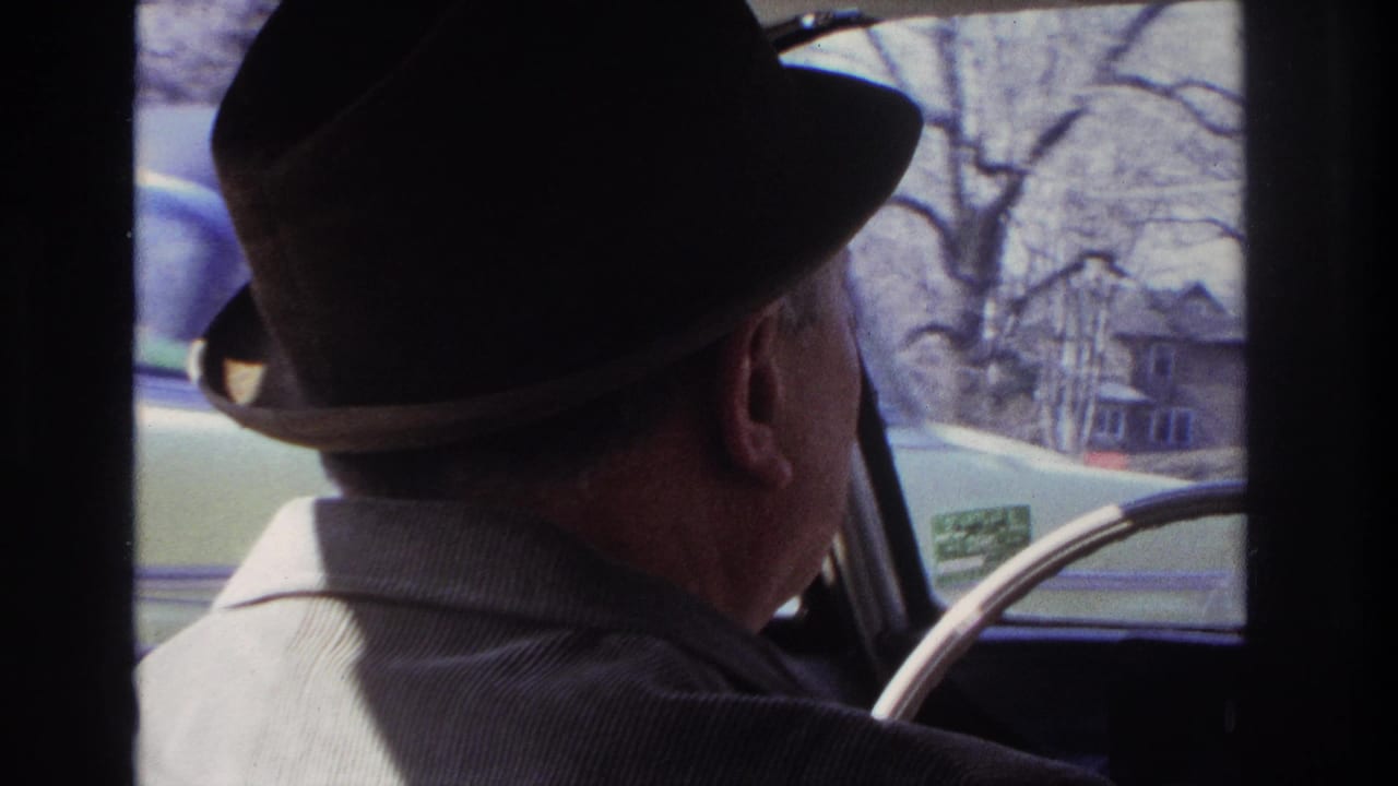 The 1966 Hoboken clip shows the driver from behind, with houses, bare trees, and the car's window frame visible outside.