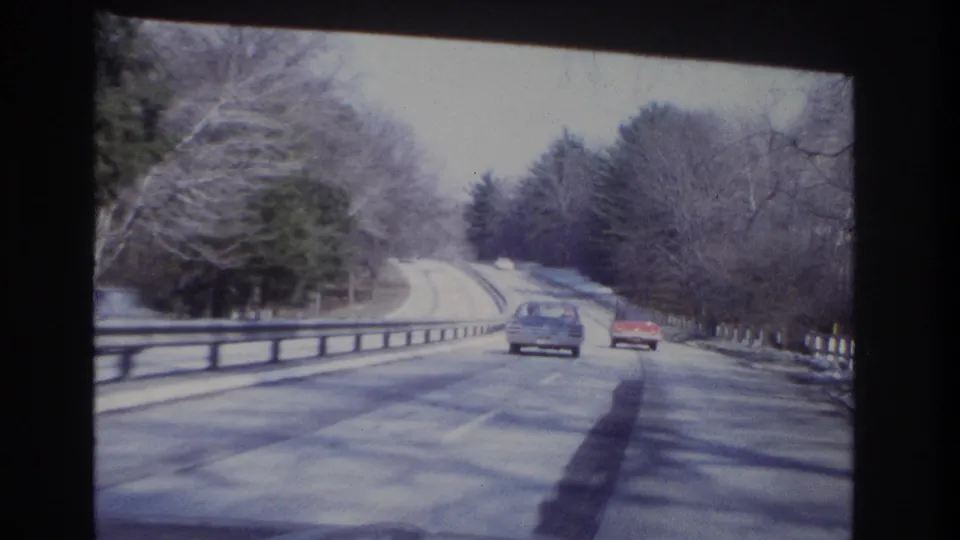 End frame of 1966 8mm driving footage showing two cars ahead on a wooded New Jersey roadway.