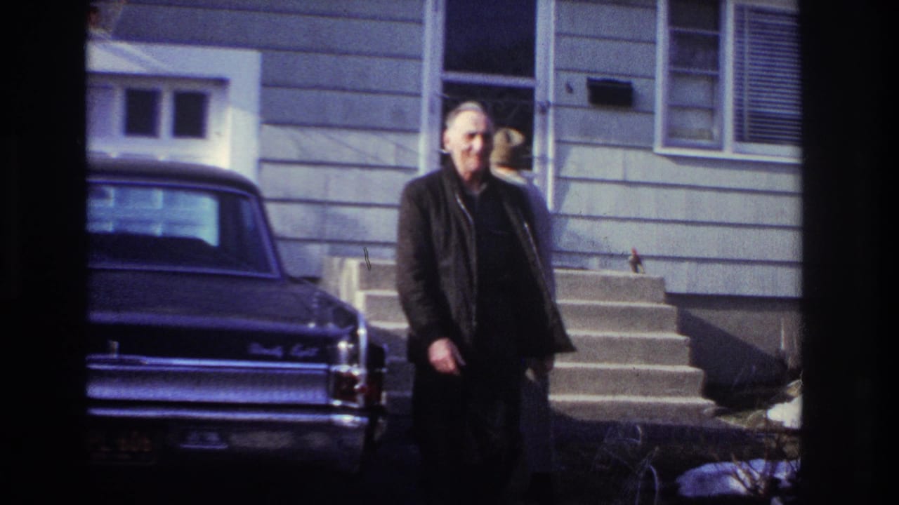 At the end of the supplied Hoboken clip, an older man walks toward the camera with the house steps and dark sedan behind him.