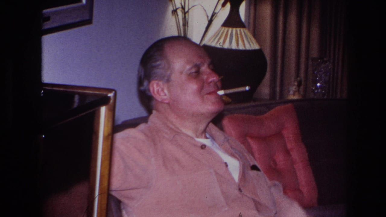 In 1966 Hoboken home-movie footage, a man in a light pink shirt sits on a dark sofa smoking beside a lamp and curtains.