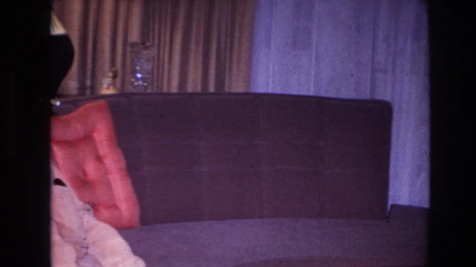 The final frame shifts to a mostly empty section of sofa, with the man cropped at left and the living room curtains and wall visible.