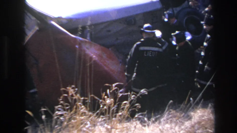 1966 Hoboken frame with a uniformed responder marked LIEUT standing near the overturned red vehicle.