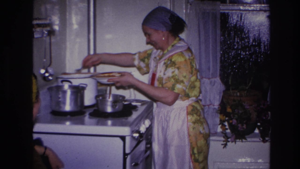 Woman holds a plate or bowl while stirring or serving food at the stove.