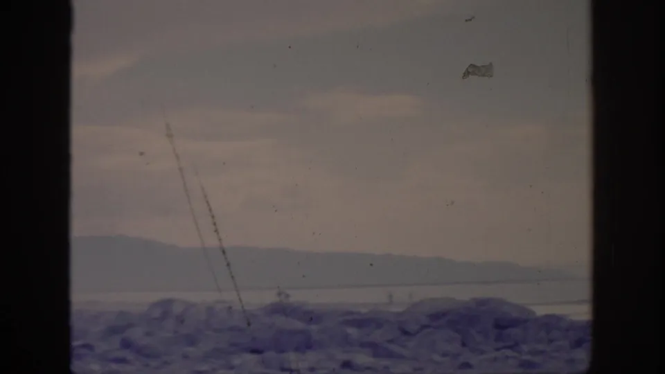 1966 Sacramento-area home-movie frame showing a hazy mountain view beyond a dark window or film border.