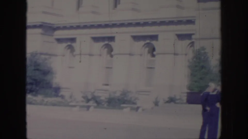1966 Sacramento frame showing a classical Capitol-area facade with two Navy-uniformed men standing near the right edge.