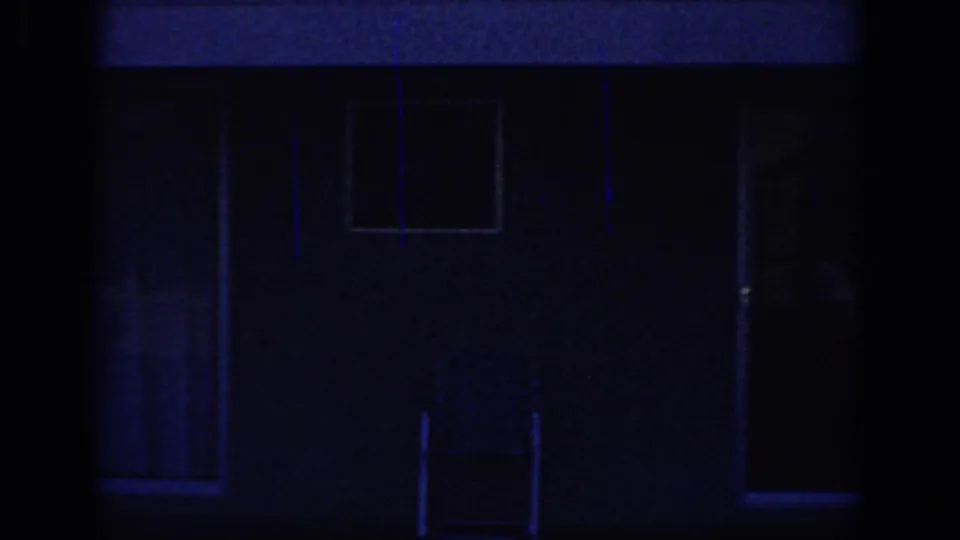 1966 Sacramento home-movie frame showing a dark house exterior with windows, deep blue cast, and a central vertical obstruction.