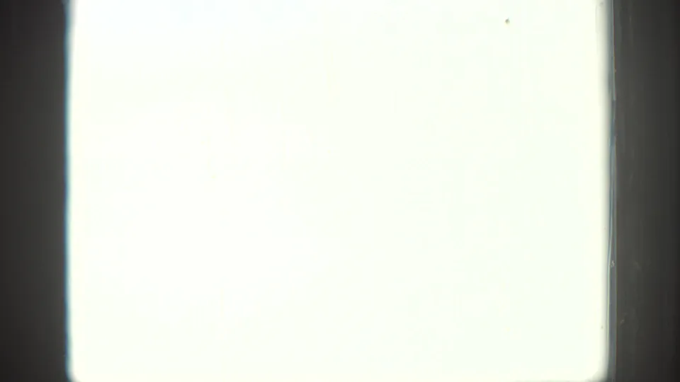 Overexposed 8mm frame section with a pale washed-out field, dark film edge, and minimal visible scene detail.