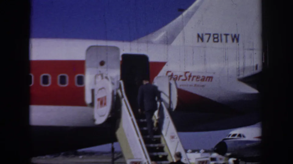 1966 Sacramento airport footage shows a suited adult boarding a StarStream-marked jet by mobile stairs, with registration text visible on the tail.