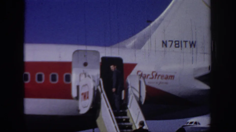 A suited adult stands by the open aircraft door of a StarStream-marked jet at Sacramento, with tail registration and red stripe visible.