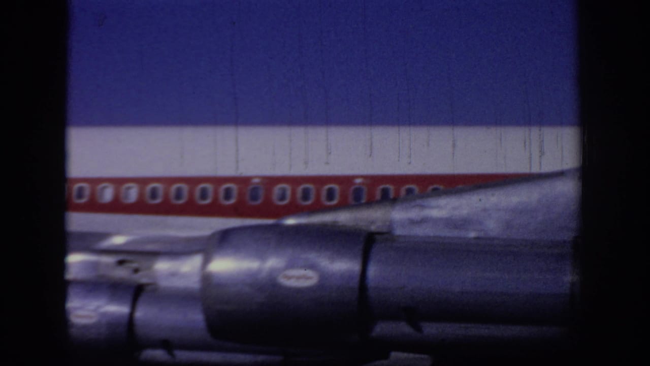1966 Sacramento frame of a red-and-white TWA jet midsection, showing passenger windows, wing root, and dark engine nacelles.