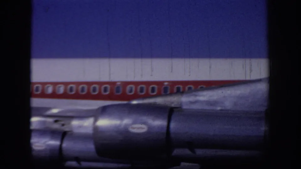 1966 Sacramento frame of a red-and-white TWA jet midsection, showing passenger windows, wing root, and dark engine nacelles.