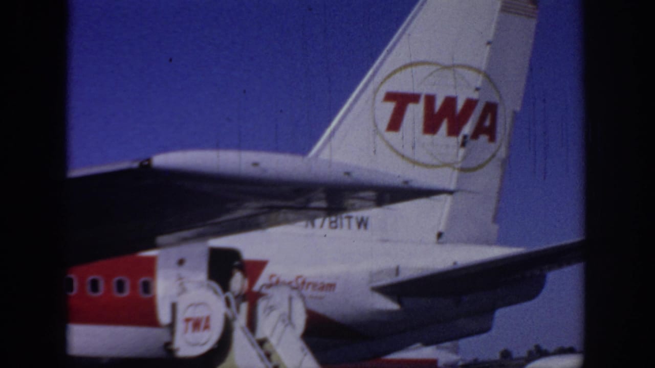 TWA airliner tail and boarding stairs seen from the tarmac.