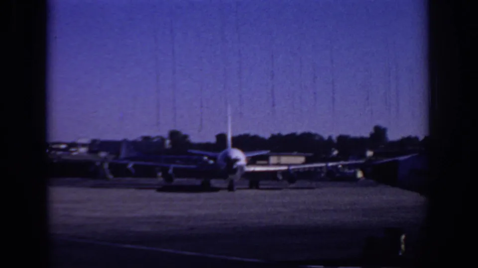 1966 Sacramento airport tarmac view with a passenger jet facing the camera and several aircraft parked behind it.
