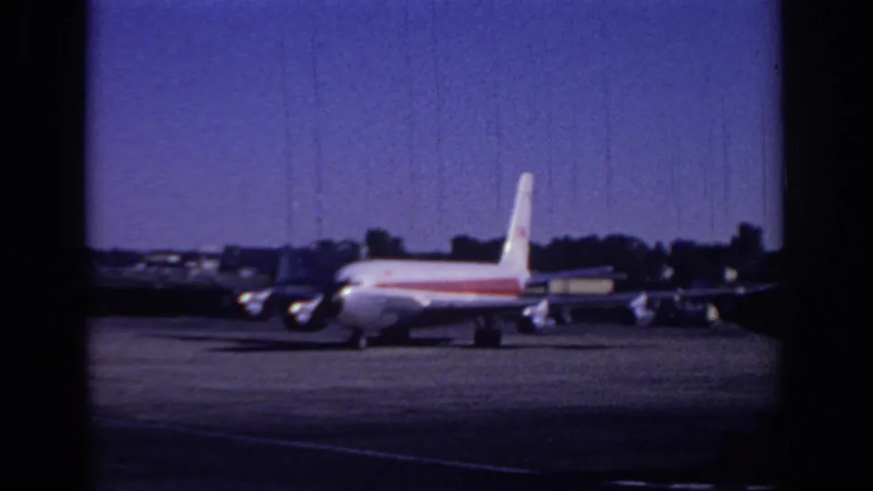 The white-and-red commercial jet remains centered on the Sacramento tarmac, with small aircraft and airport structures behind it.