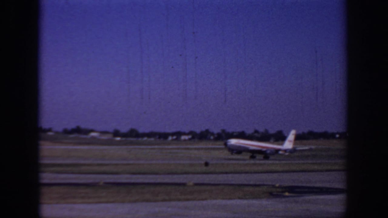 Commercial jet near the runway with its nose raised slightly against the airfield horizon.
