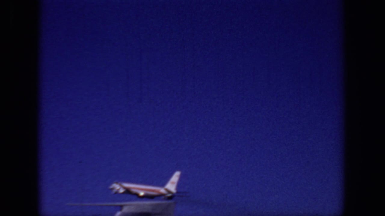 Small jet aircraft lifting above a runway edge against a deep blue sky.