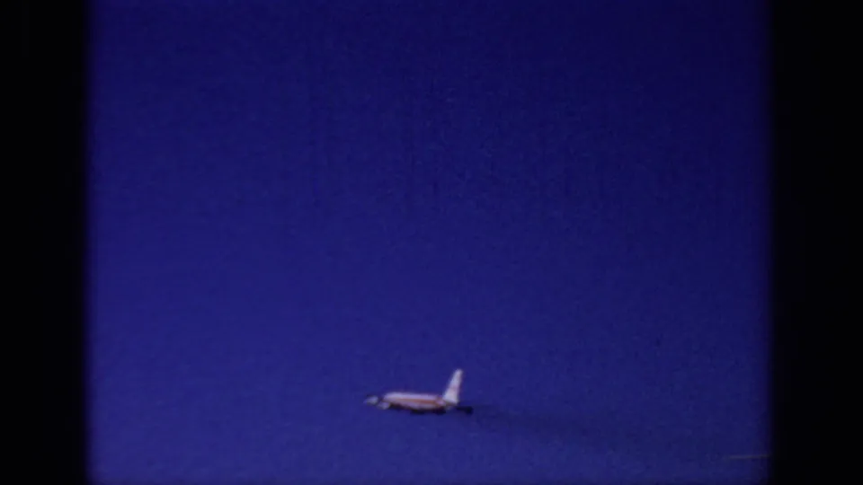 A small striped jet recedes into open blue sky in the 1966 Sacramento 8mm takeoff sequence.